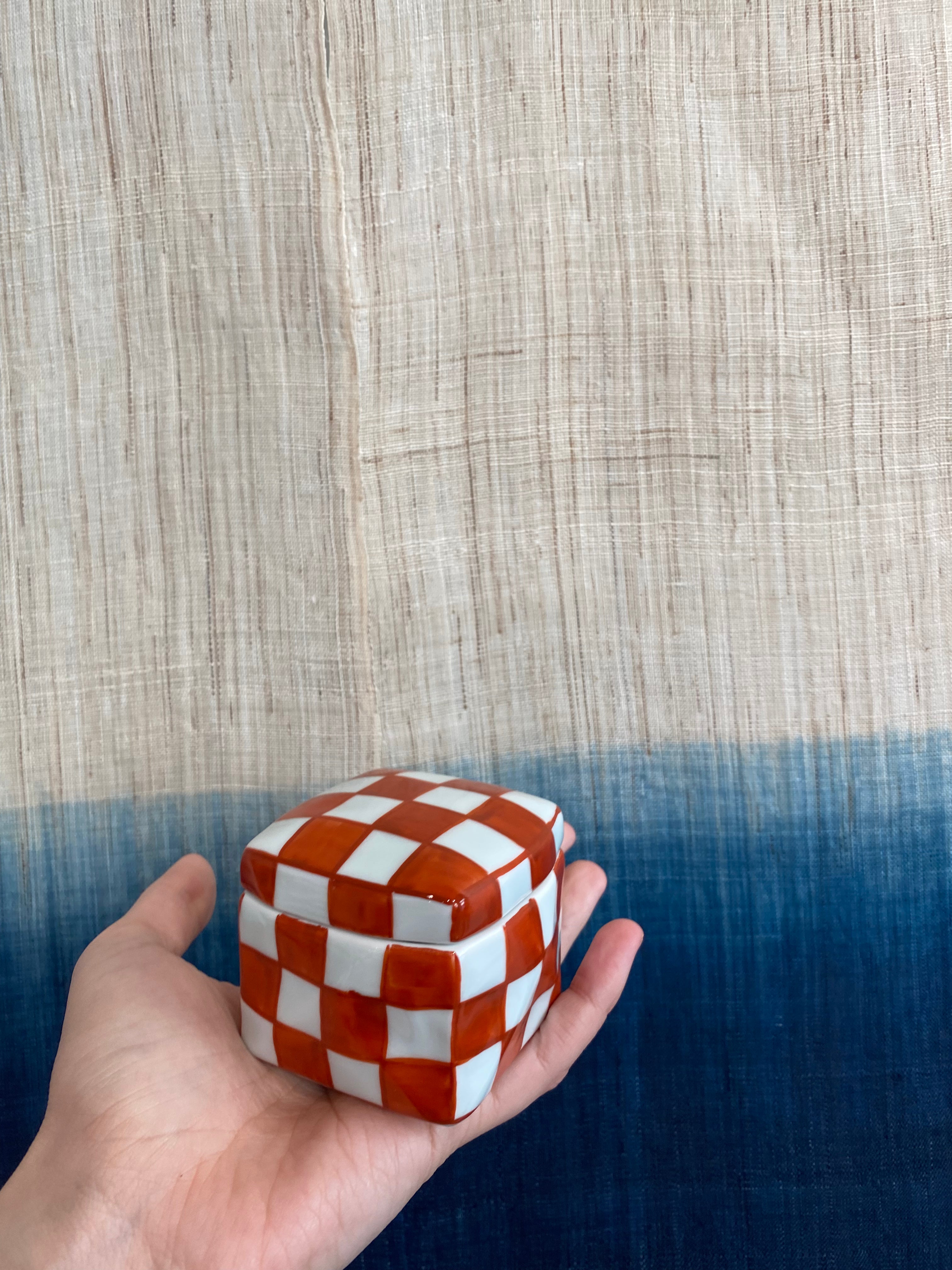 Handmade lidded jar with red/white checkered glaze