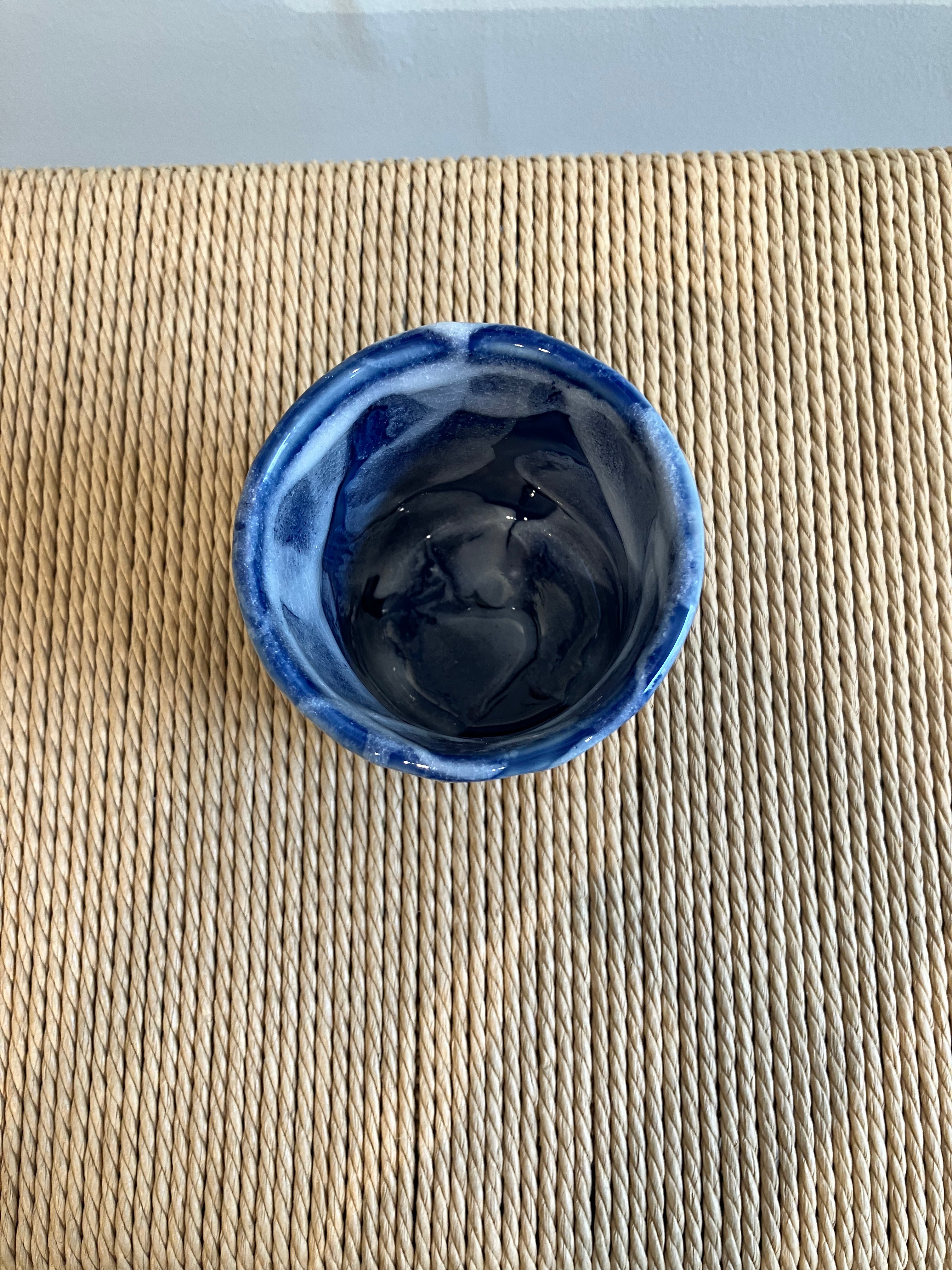 Ceramic cup with blue glaze and white details