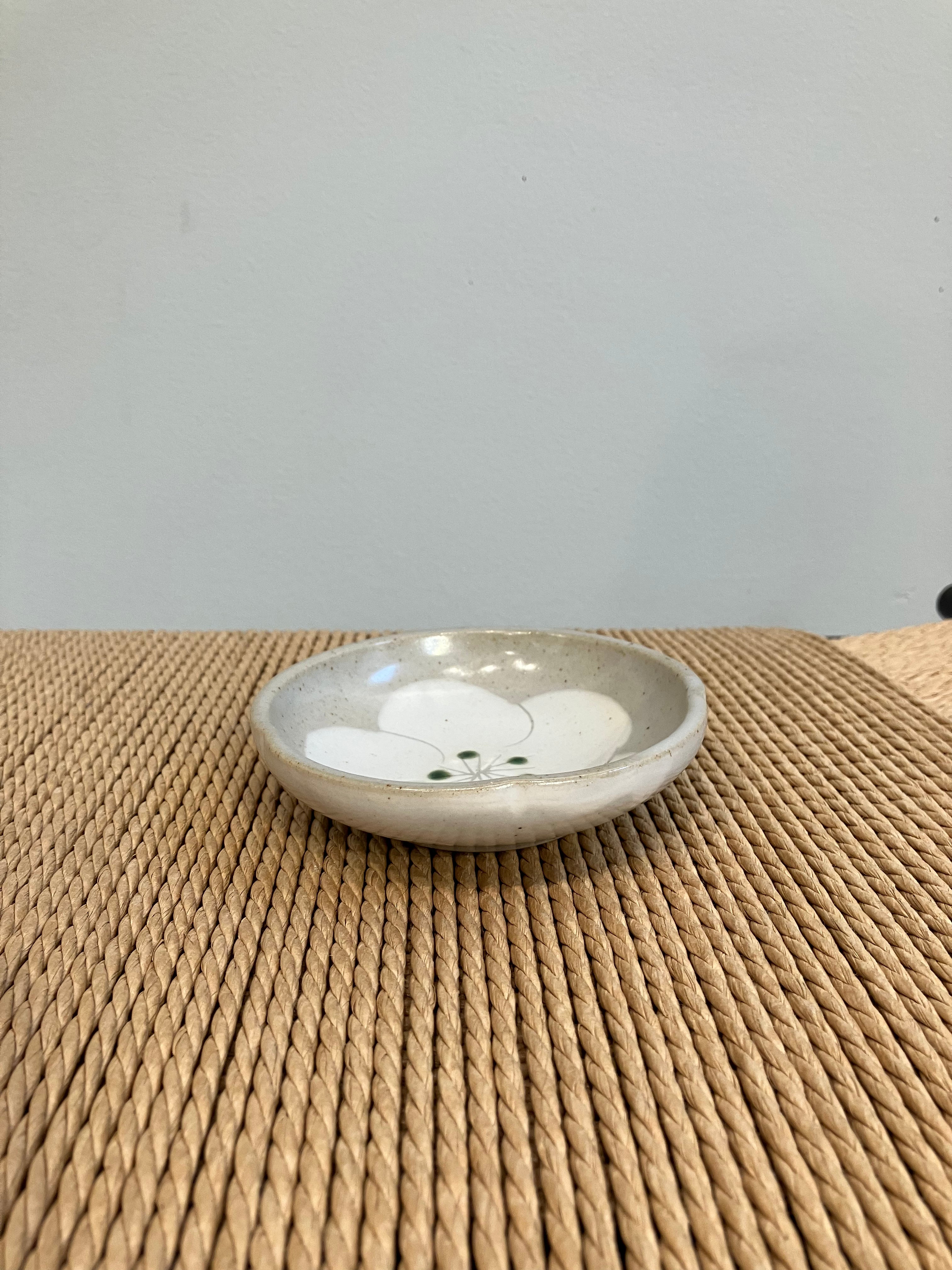 Lille grå skål med hvid blomst og grønne prikker